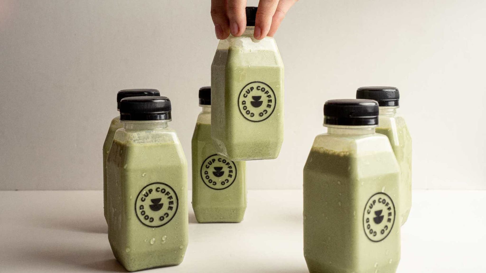 Bottled iced matcha drinks with circular Good Cup Coffee Co. labels