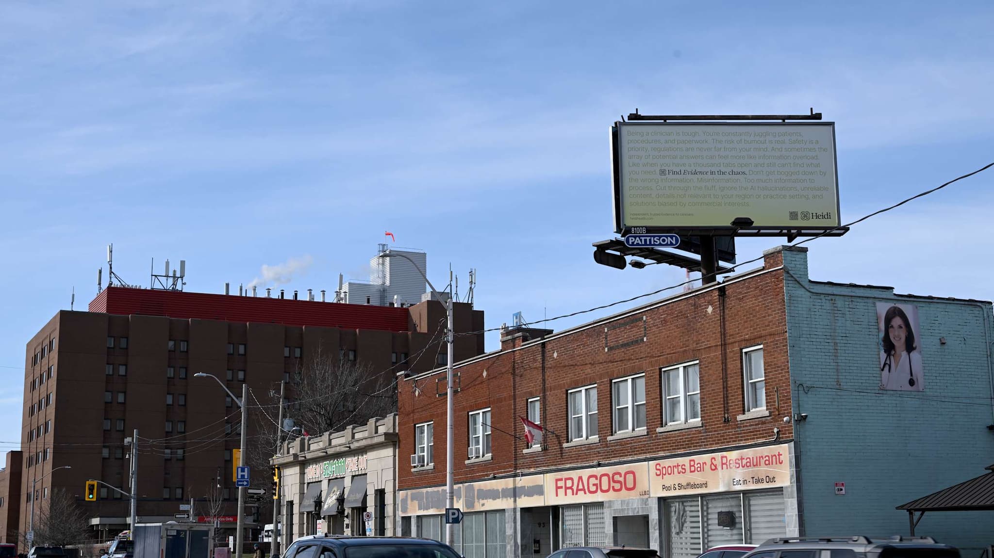Heidi billboard above a brick building on a city street