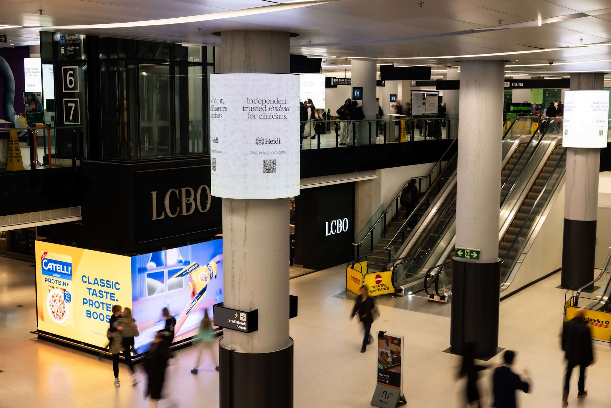 Transit concourse beside an LCBO store with a Heidi ad on a pillar